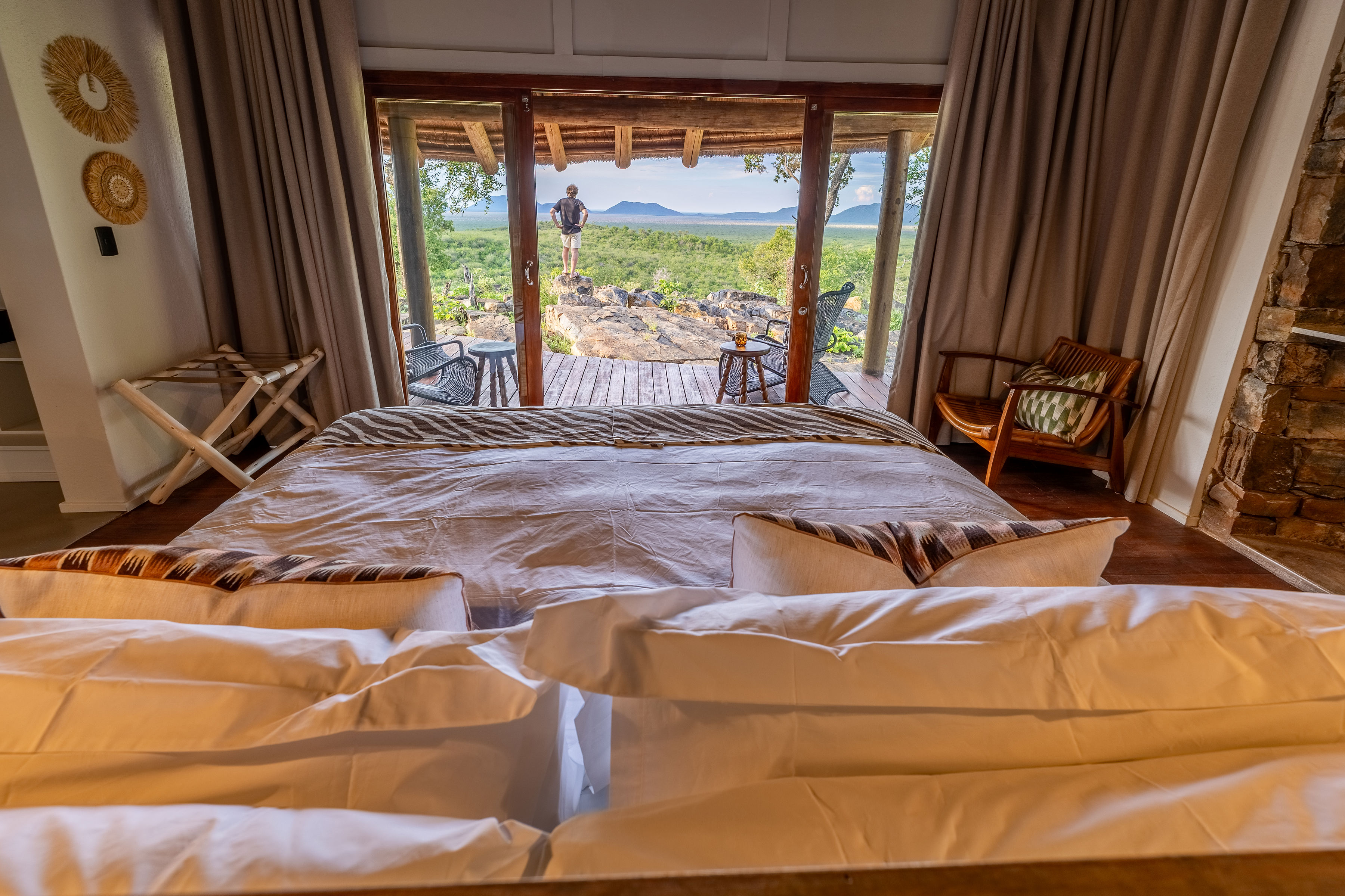 Luxury safari lodge bedroom with panoramic bush view